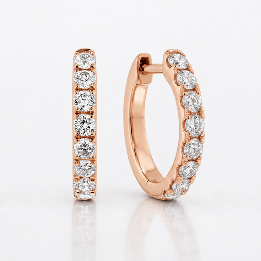 A pair of rose gold huggie hoop earrings, one shown flat and the other in profile, both adorned with a row of round-cut clear diamonds on a clean white background.