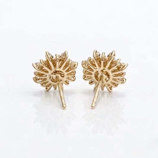A pair of gold dandelion stud earrings with intricate petal details and post backs, displayed on a clean white reflective surface.