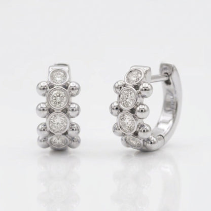18K white gold Orbi Collection natural diamond bezel and gold bead huggie earrings, front and angled view