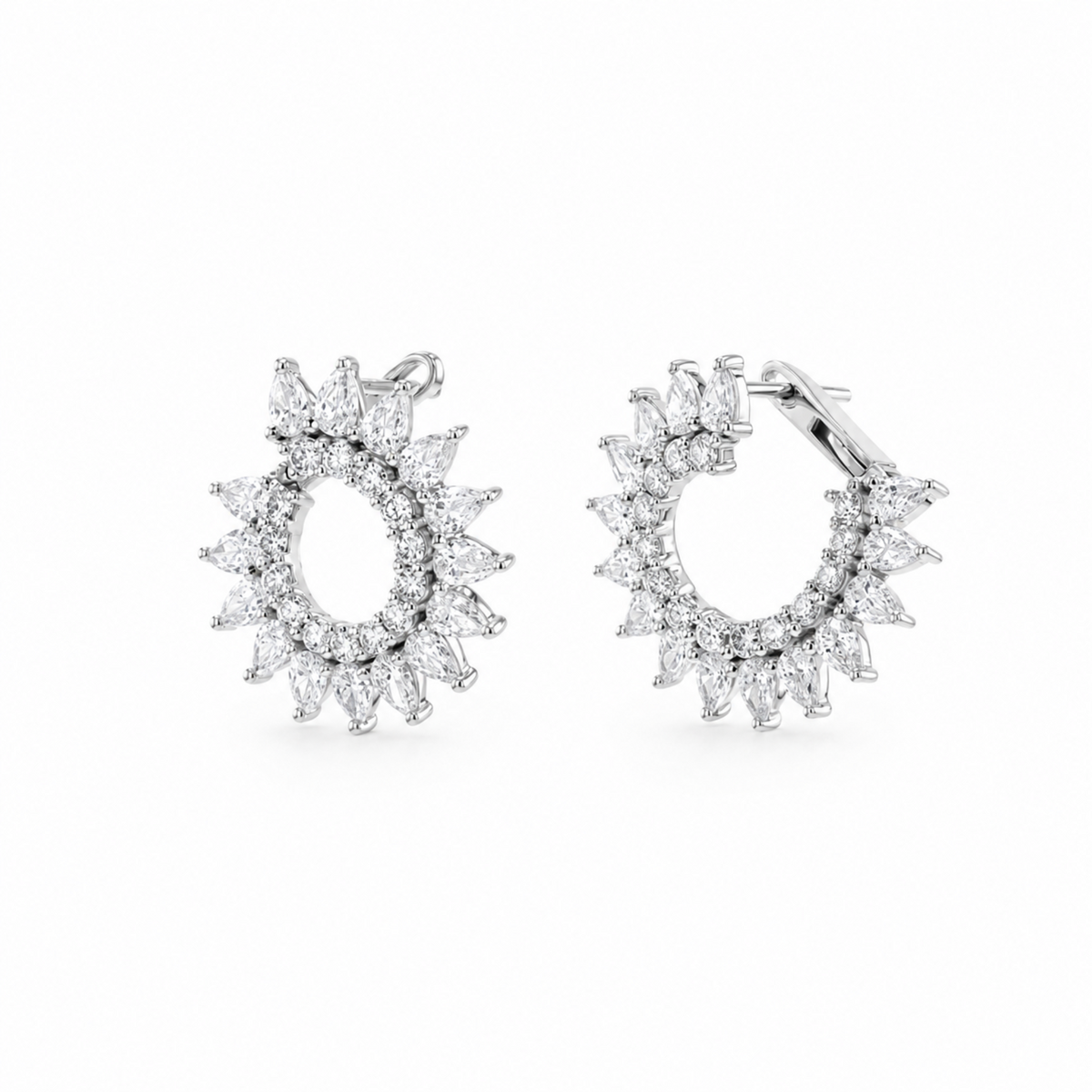 A pair of silver hoop earrings with marquise-cut clear  diamonds. arranged in a sunburst or flower-like halo design, shown on a plain white background.