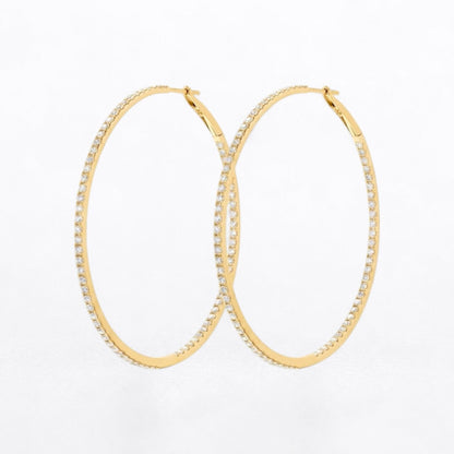 A pair of gold hoop earrings embellished with small clear diamonds along the outer edges, displayed on a clean white background.
