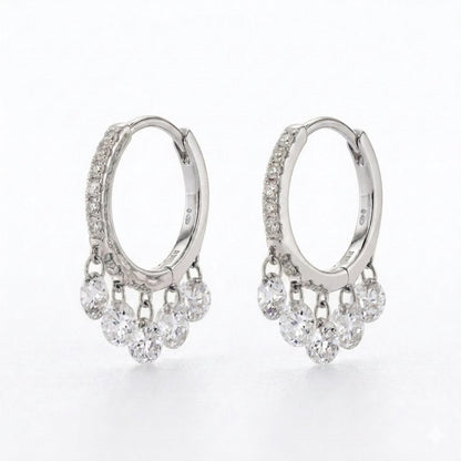 A pair of silver hoop earrings with small clear diamonds along the front and five clear dangling round diamonds stones on each earring, shown on a white background.