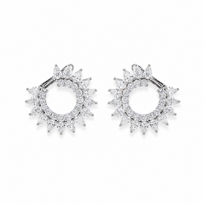 A pair of silver-toned hoop earrings with a sunburst halo design, set with clear marquise-cut and round-cut  diamonds., shown on a plain white background.