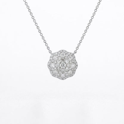 A silver-toned necklace with a round pavé pendant set with small clear diamonds, shown against a plain white background.