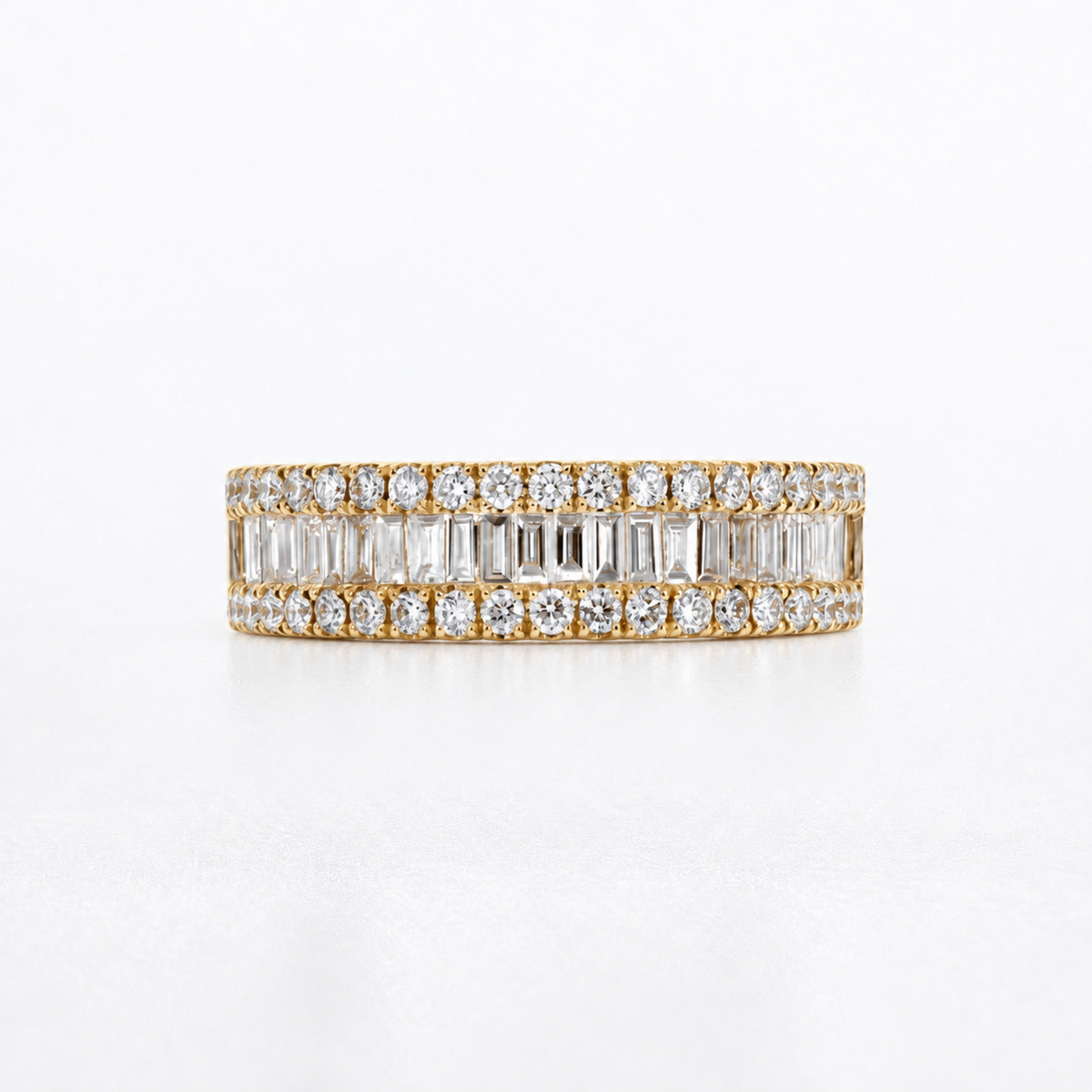 A yellow gold eternity ring featuring double rows of baguette and round-cut clear diamonds, photographed on a clean white background.