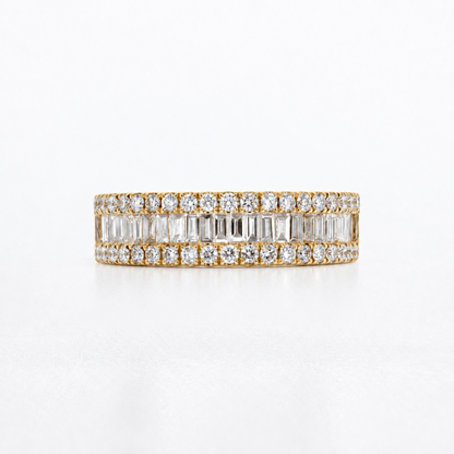 A yellow gold eternity ring featuring double rows of baguette and round-cut clear diamonds, photographed on a clean white background.