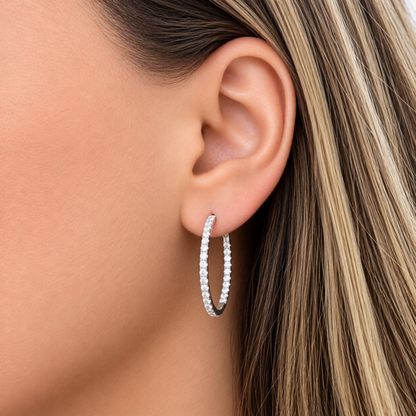 Model wearing 1-inch natural diamond inside-out hoop earrings in solid 18K white gold.