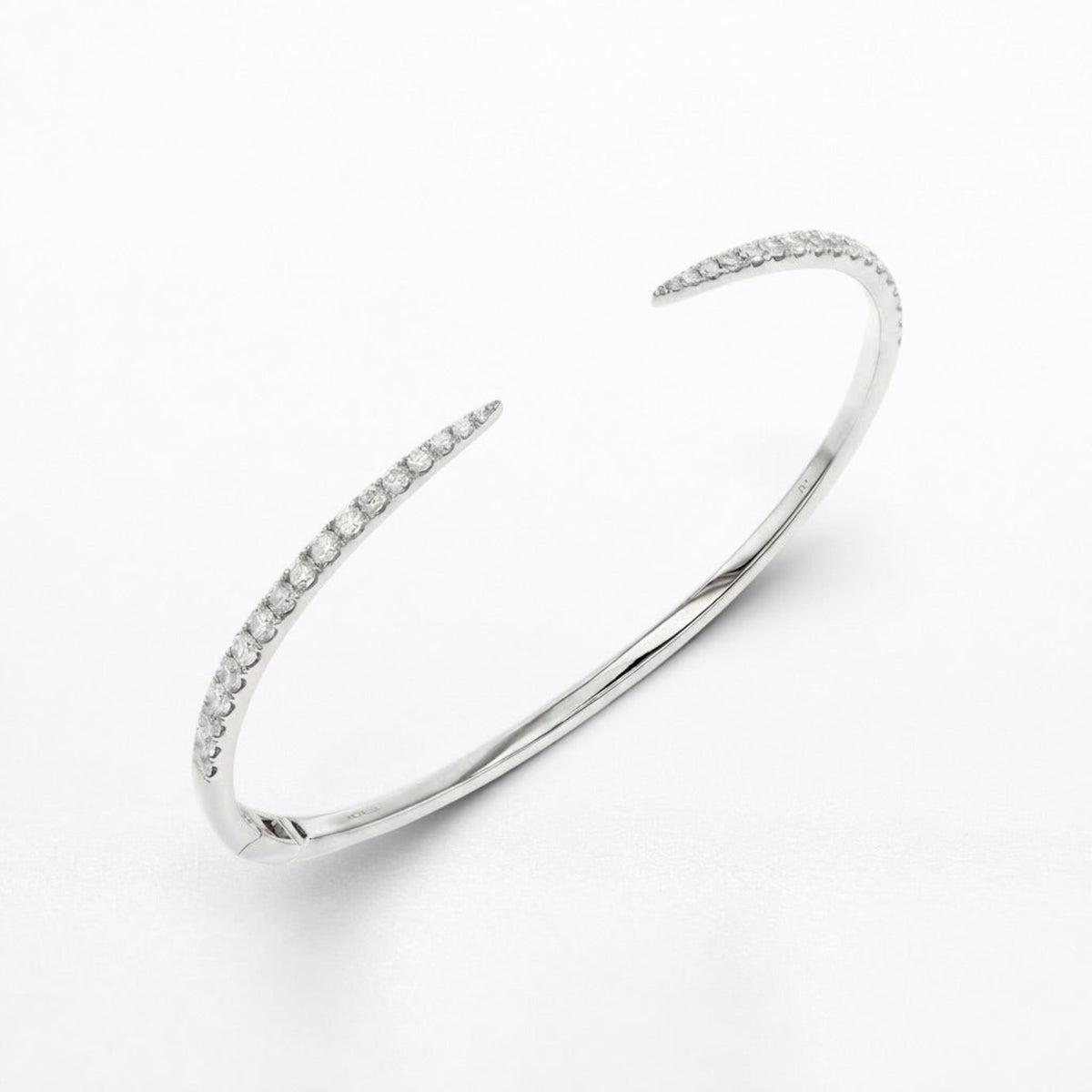 A polished silver-tone open cuff bangle bracelet with delicate rows of clear pavé diamonds along both open ends, displayed on a clean white background.