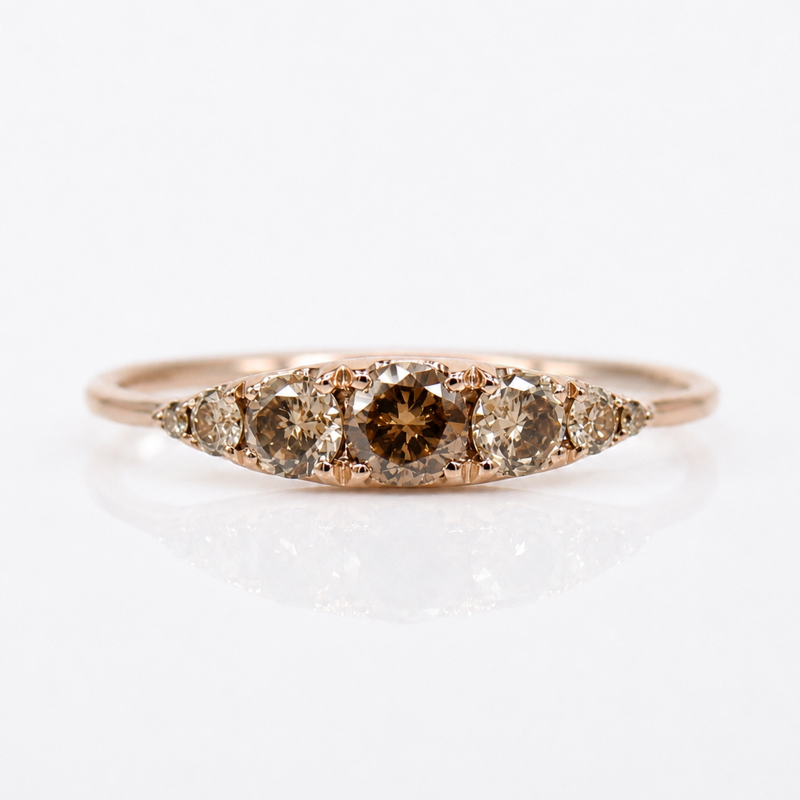 A rose gold ring featuring a marquise-shaped cluster of brown diamonds, including a prominent center diamond with a brown tint, set against a clean white background.