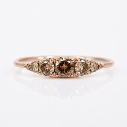 A rose gold ring featuring a marquise-shaped cluster of brown diamonds, including a prominent center diamond with a brown tint, set against a clean white background.