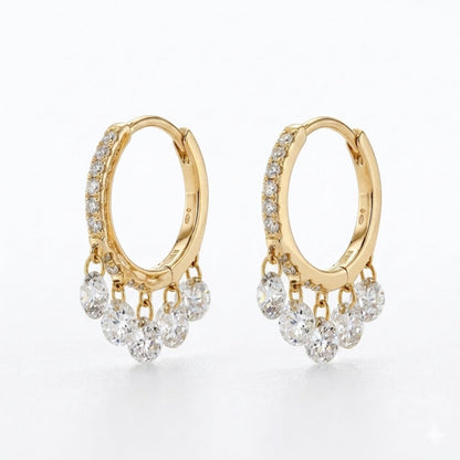A pair of gold huggie hoop earrings with rows of small clear diamonds along the front and five dangling clear round diamonds at the bottom, shown on a clean white background.