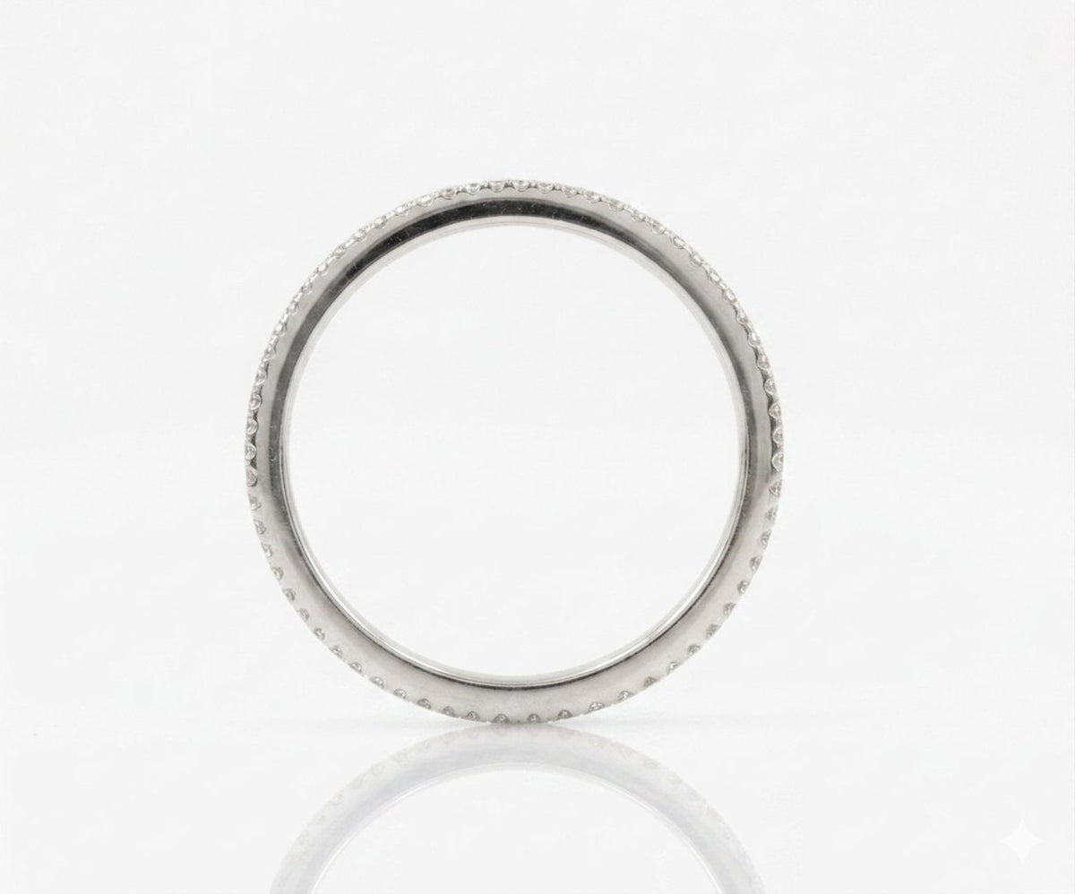 A silver-toned ring with a textured, beaded outer edge, shown on a clean white reflective surface.