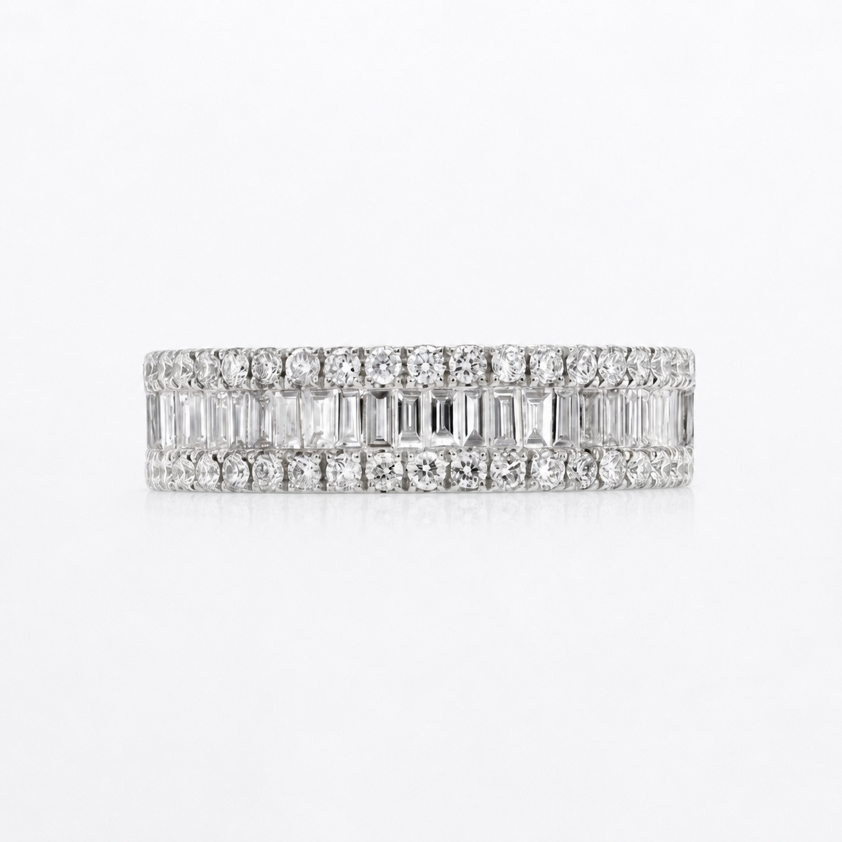A diamond eternity band ring in white gold or platinum, featuring rows of round and baguette-cut diamonds, shown on a clean white background.