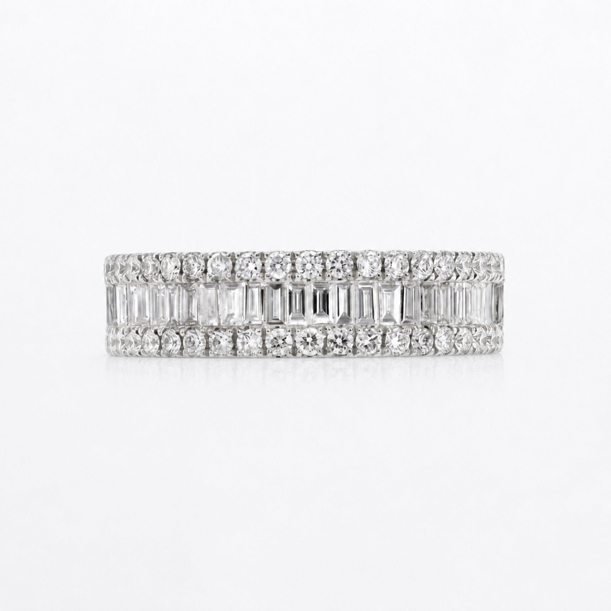 A diamond eternity band ring in white gold or platinum, featuring rows of round and baguette-cut diamonds, shown on a clean white background.