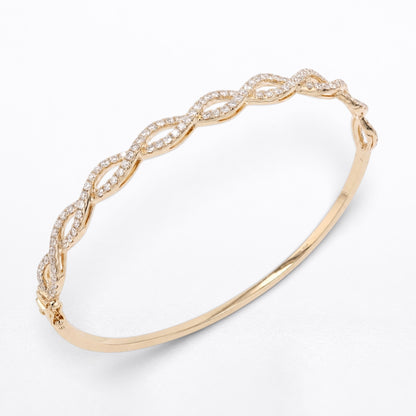 A slim yellow gold bangle bracelet featuring an openwork, twisted wave pattern paved with small clear diamonds, shown on a clean white background.
