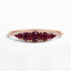 Low profile 14K rose gold arc ring with seven graduated natural rubies