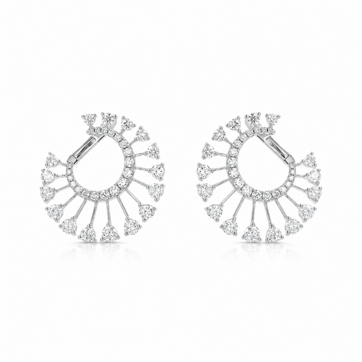 A pair of silver-toned hoop earrings decorated with multiple rows of clear pavé stones and triangular dangling accents, shown on a clean white background.