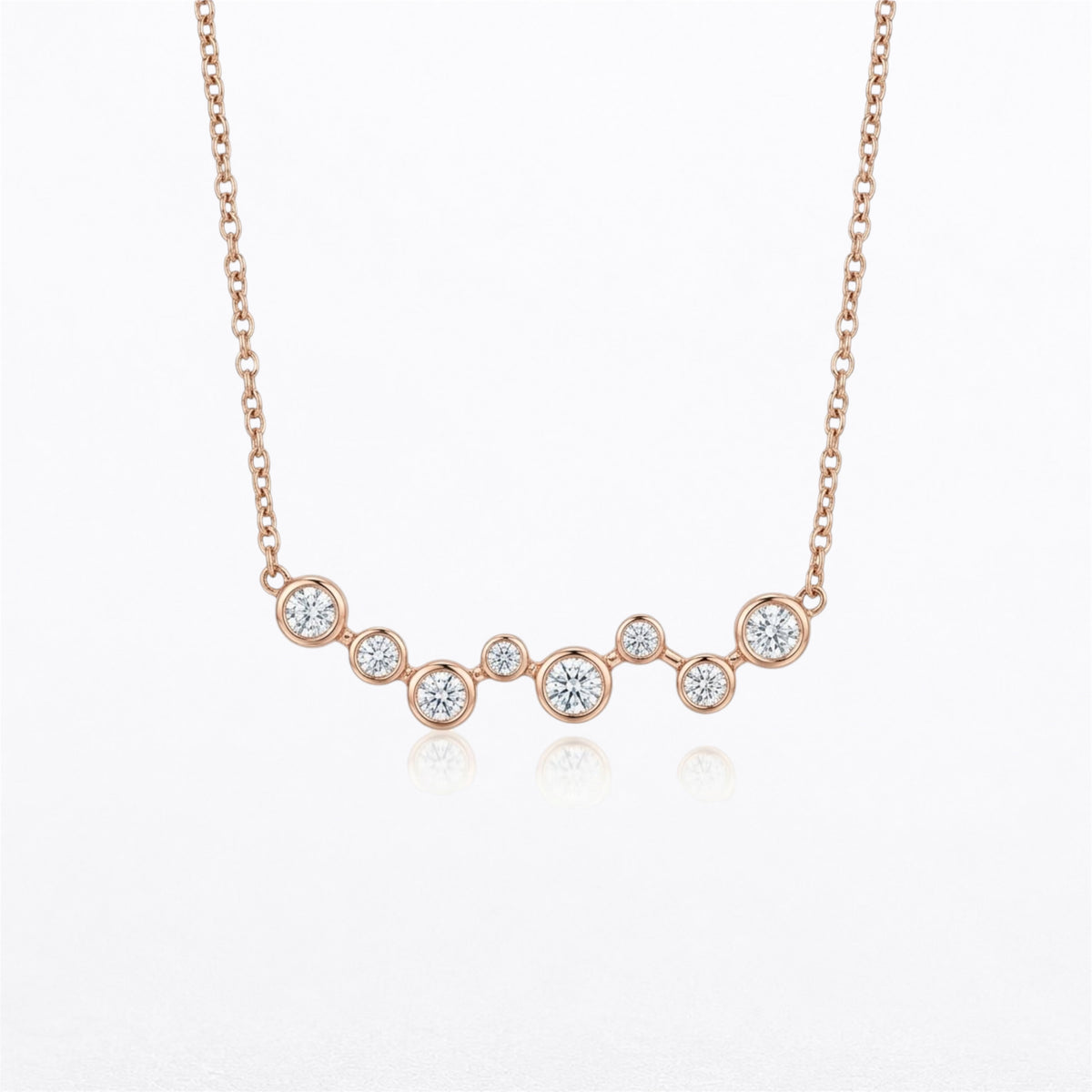 14K rose gold graduated bezel-set natural diamond necklace featuring eight round brilliant diamonds totaling 0.40 carats on an adjustable gold chain.