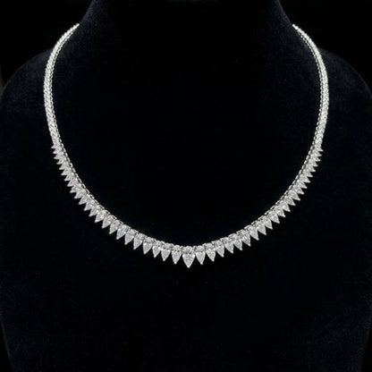 Pear-shaped and round natural diamond tennis necklace in 18K white gold displayed on a black velvet bust