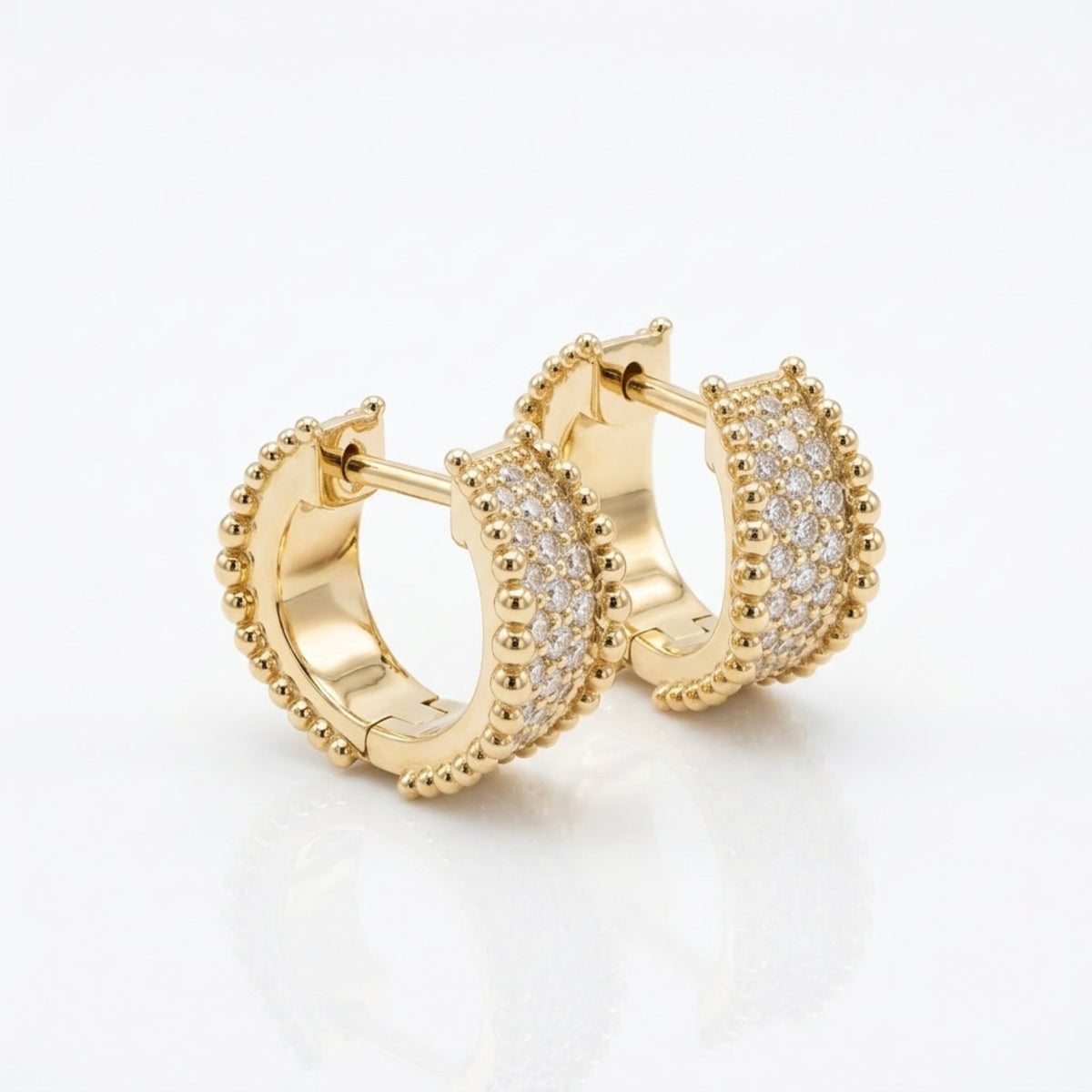 Angled view of 12mm Orbi natural diamond and gold bead huggie earrings in 14K yellow gold