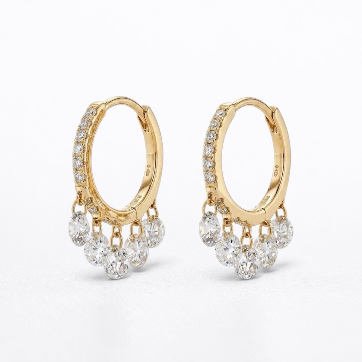 A pair of gold hoop earrings with dangling clusters of clear round-cut diamonds, photographed on a clean white background.