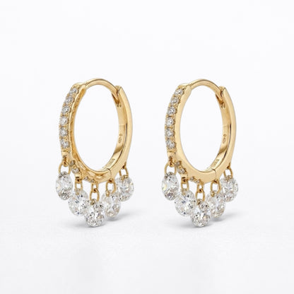A pair of gold hoop earrings with dangling clusters of clear round-cut diamonds, photographed on a clean white background.