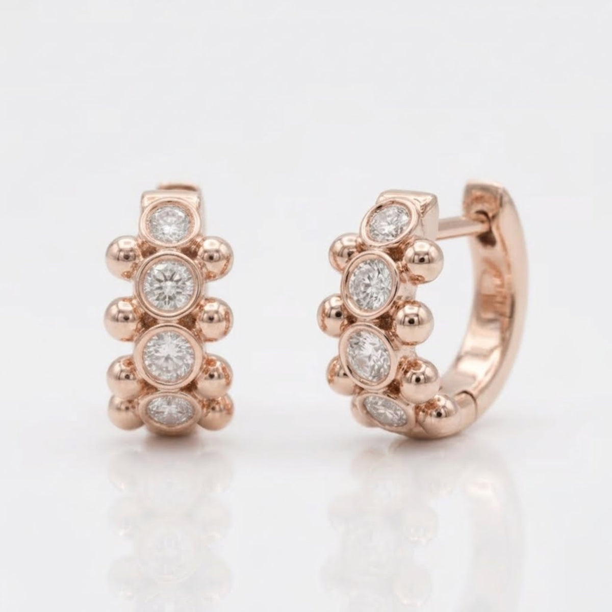 18K rose gold Orbi Collection natural diamond bezel and gold bead huggie earrings, front and angled view