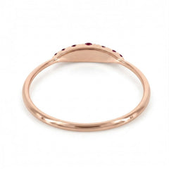 A rose gold signet ring with a small row of red ruby along the top curve, shown on a clean white background.