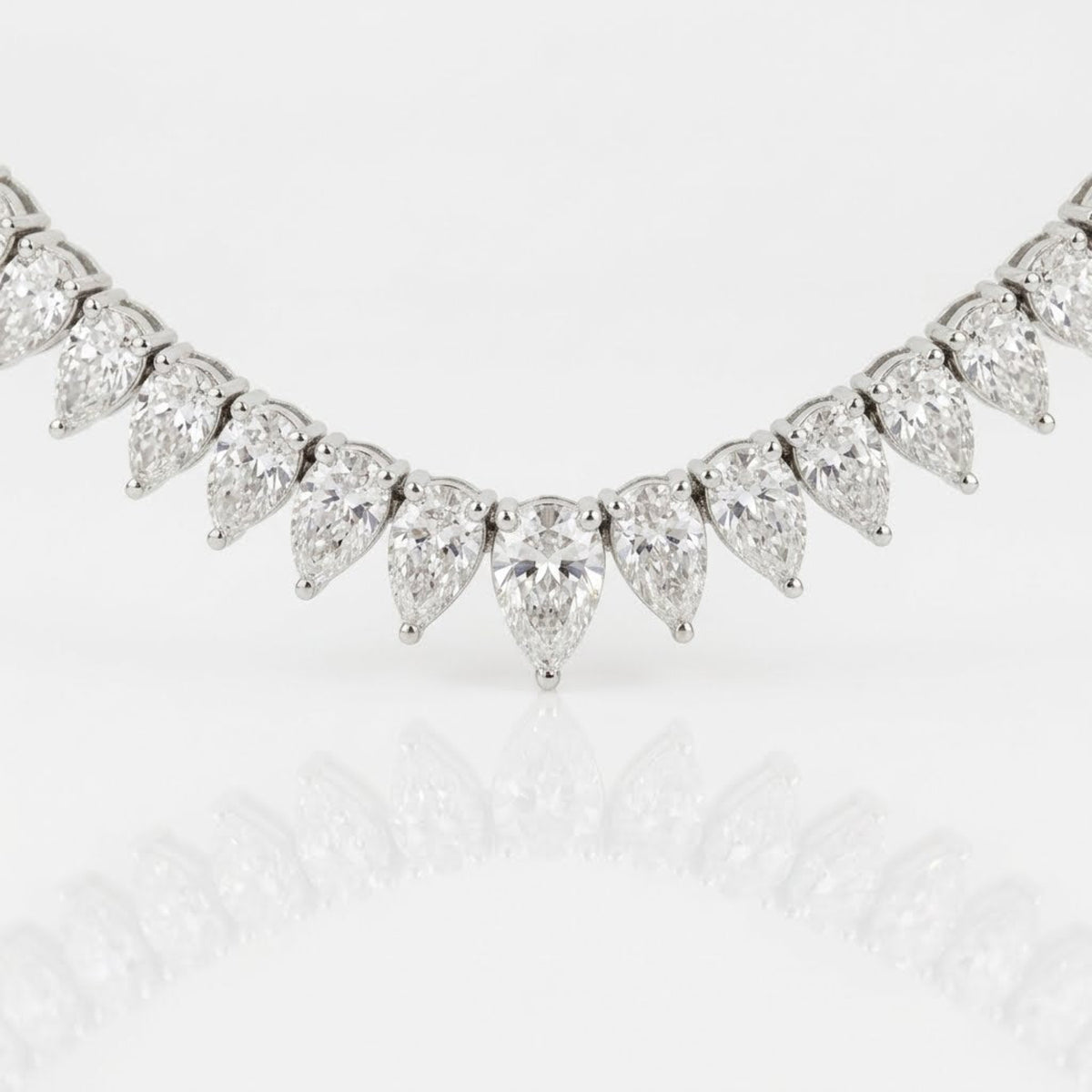 Close-up of graduated pear-shaped natural diamonds at the center of the 18K white gold diamond tennis necklace