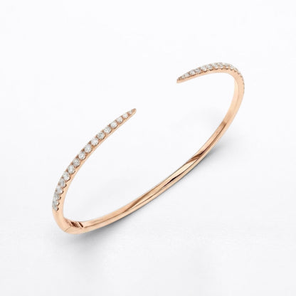 A slim open cuff bangle bracelet in polished rose gold, featuring rows of small clear pavé-set diamonds along both curved ends, shown on a clean white background.