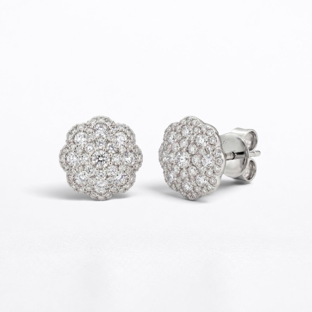 A pair of round cluster stud earrings in silver-tone metal, featuring pavé-set clear diamonds and a post-back closure, shown on a clean white background.
