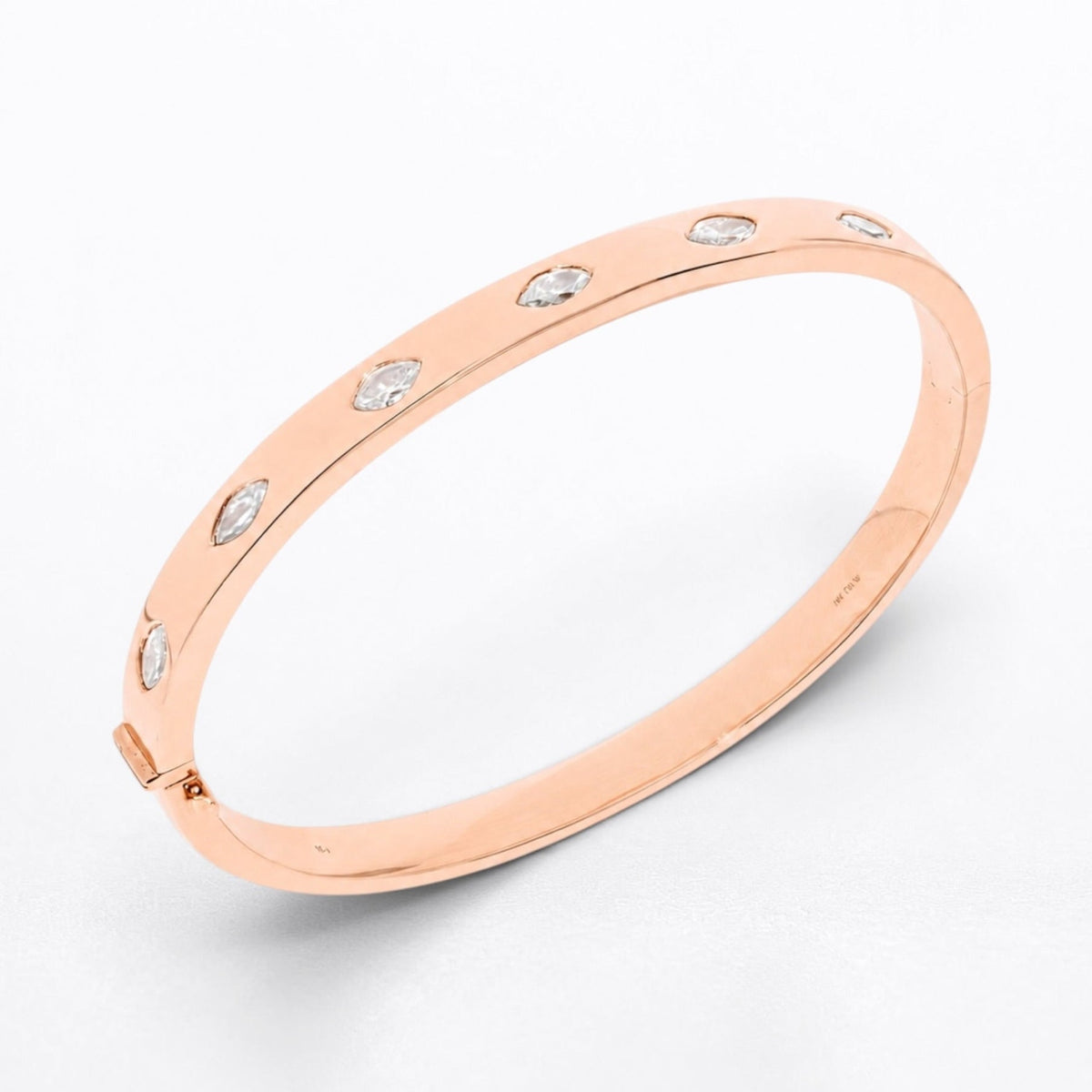 A slim rose gold bangle bracelet with five small marquise shaped clear diamonds set along the outer band, photographed on a clean white background.