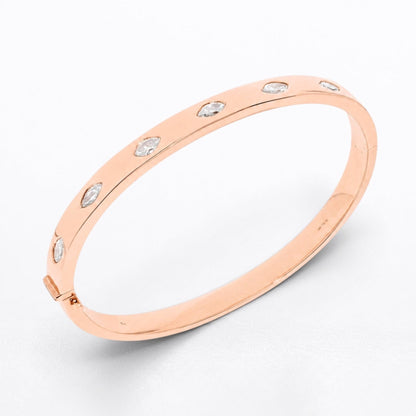 A slim rose gold bangle bracelet with five small marquise shaped clear diamonds set along the outer band, photographed on a clean white background.