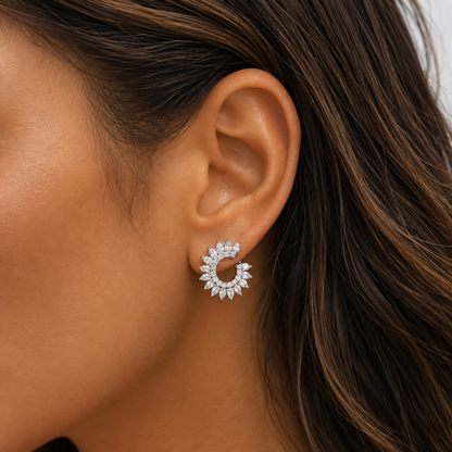 A close-up of a woman's ear wearing a silver crescent-shaped stud earring set with clear marquise-cut diamonds.