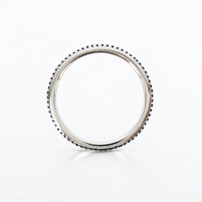 A polished silver ring with a textured, beaded outer edge, photographed on a clean white background.