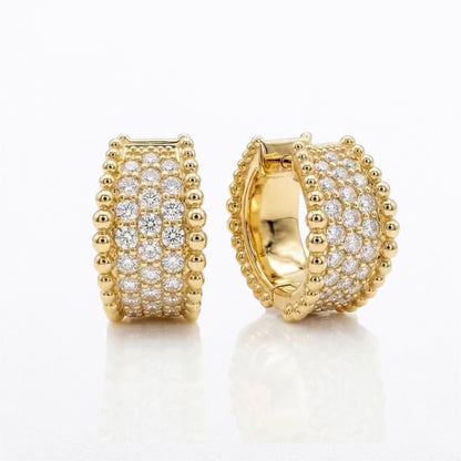 Pair of 14K yellow gold natural diamond pavé huggie hoop earrings with multiple rows of round diamonds and polished gold beaded edges, front and side views.