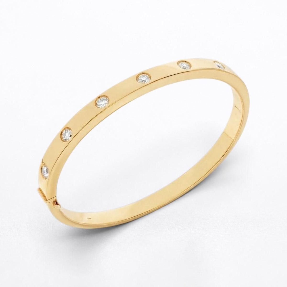 A slim yellow gold bangle bracelet with evenly spaced round-cut clear diamonds, shown on a clean white background.