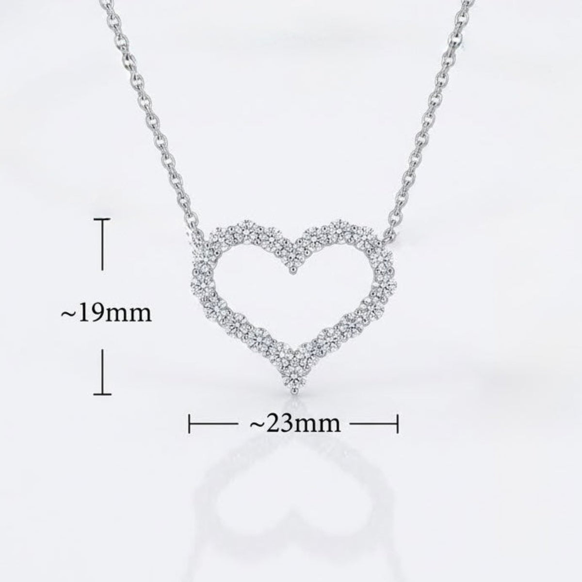 Silver heart-shaped open pendant necklace with tiny cleardiamonds, shown on a white background with dimension markers indicating approximately 19mm height and 23mm width.