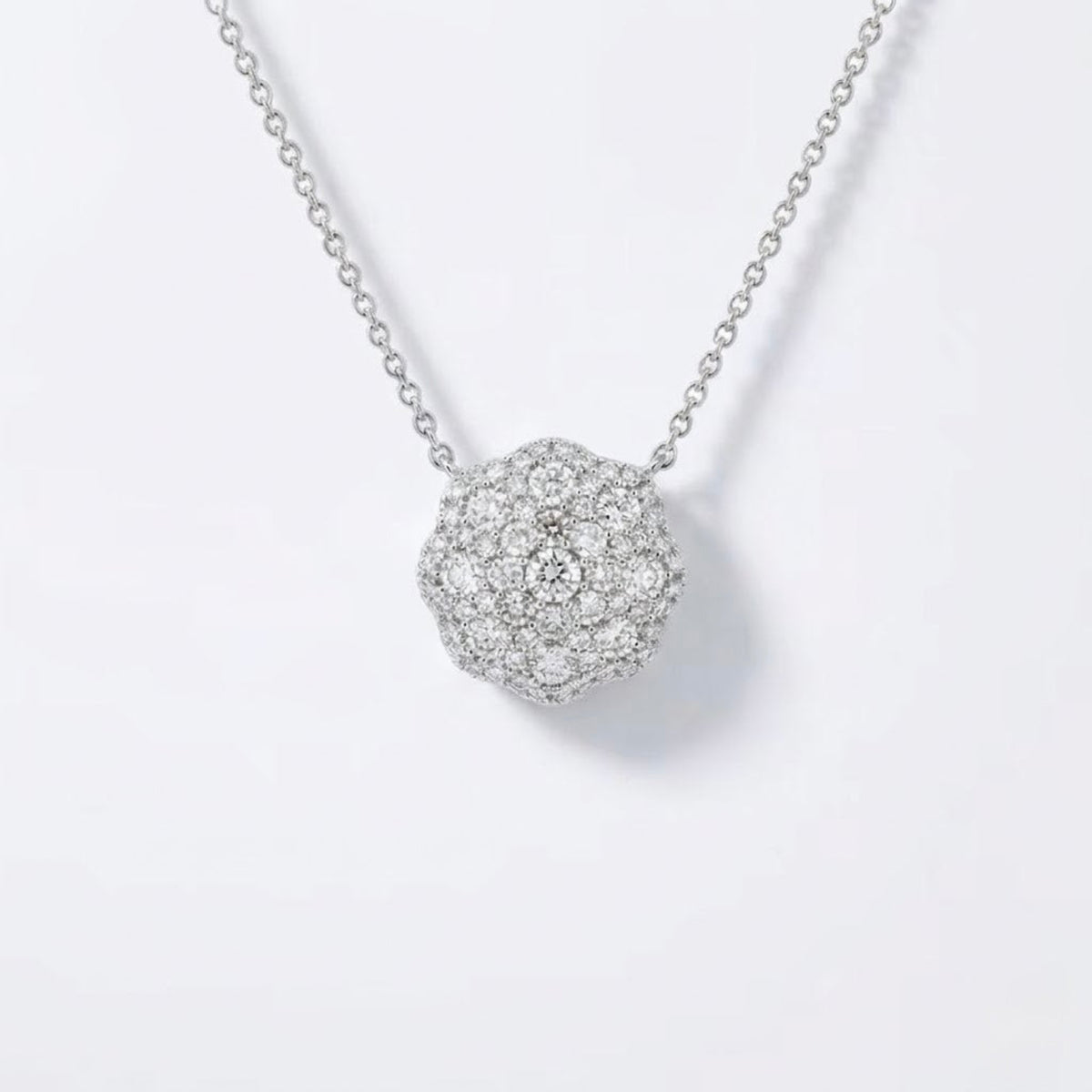 A silver pavé ball pendant necklace with a delicate chain, displayed on a clean white background.