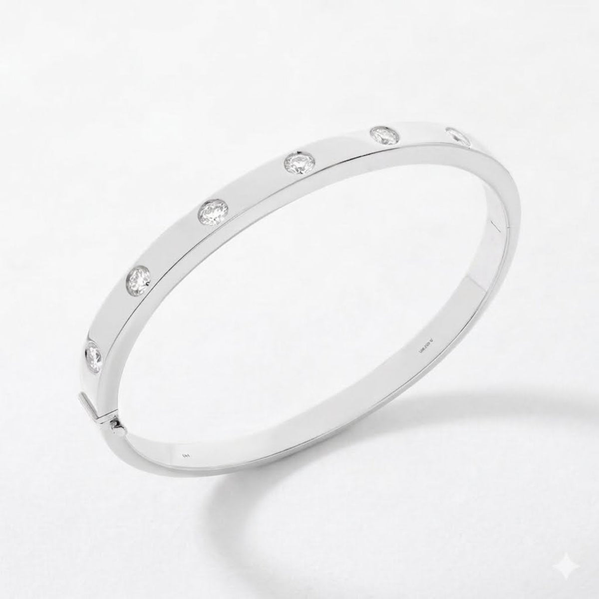 A slim white gold bangle bracelet with evenly spaced round-cut clear diamonds, displayed on a clean white background.