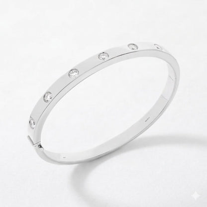 A slim white gold bangle bracelet with evenly spaced round-cut clear diamonds, displayed on a clean white background.