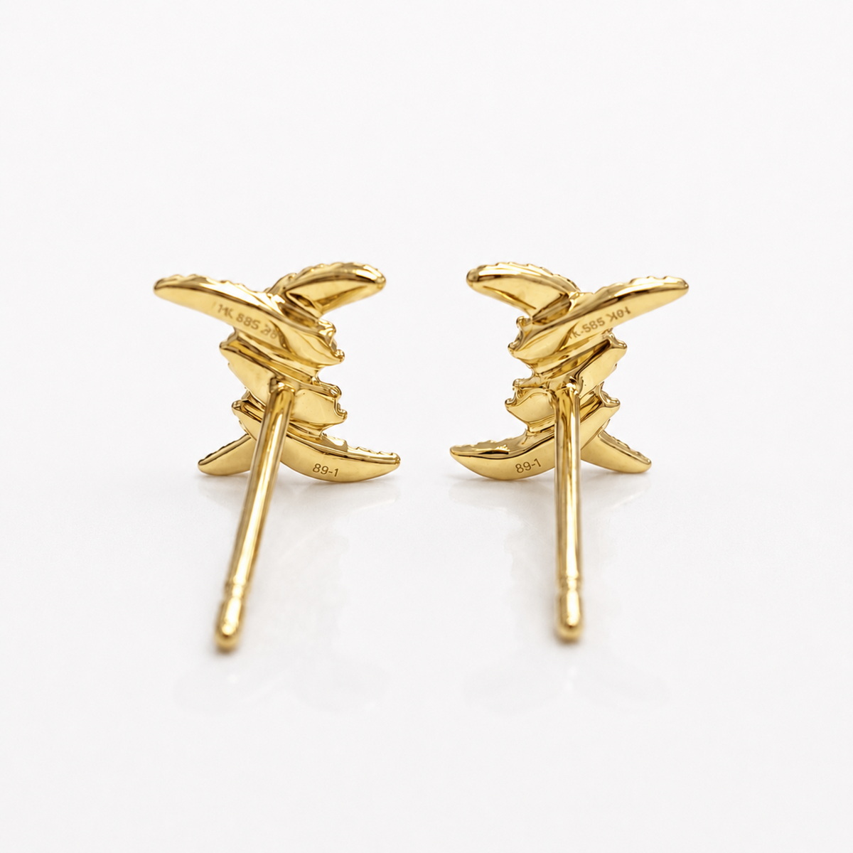 A pair of gold leaf stud earrings shown from the back on a clean white background, with '14K GOLD' stamped on the inner backs.