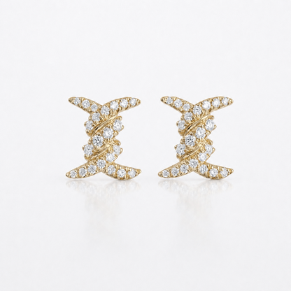 A pair of gold earrings with a twisted, spiral design paved with small clear diamonds, set against a clean white background.