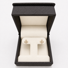 A pair of gold cross stud earrings with small clear diamonds, displayed on a cream-colored T-stand inside an open black textured jewelry box on a white background.