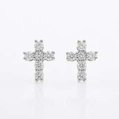 A pair of silver cross stud earrings set with small clear round-cut diamonds, displayed on a clean white reflective surface.