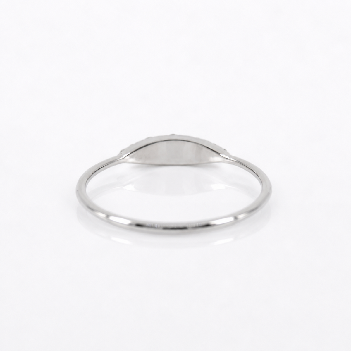 A minimalist silver signet ring with a smooth, polished oval face, displayed on a clean white background.