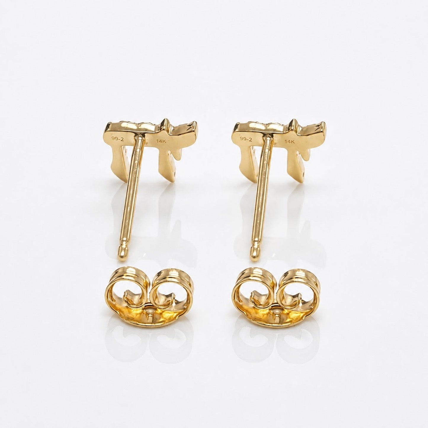 A pair of yellow gold stud earrings shown from the back on a clean white reflective surface. Each earring features a butterfly-shaped post with a matching butterfly-shaped backplate.
