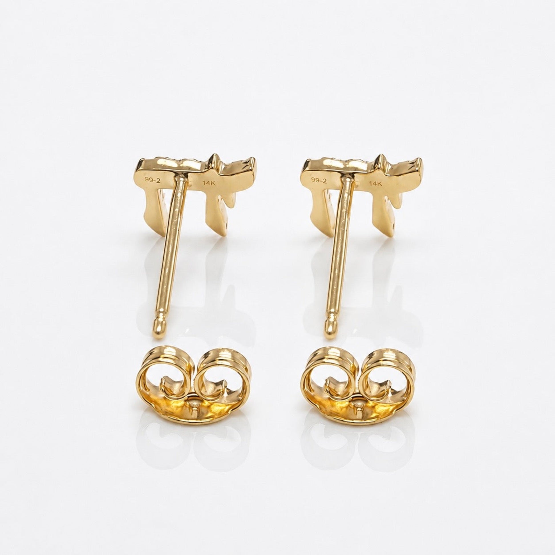 A pair of yellow gold stud earrings shown from the back on a clean white reflective surface. Each earring features a butterfly-shaped post with a matching butterfly-shaped backplate.