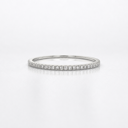 A thin silver diamond eternity ring with a continuous row of small round-cut diamonds on a polished band, shown against a clean white background.