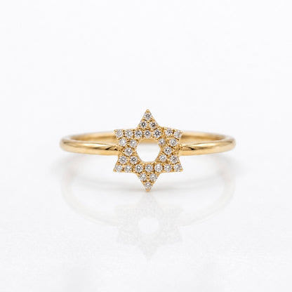 A gold ring featuring a six-pointed star pavé-set with small clear diamonds, shown on a clean white reflective surface.